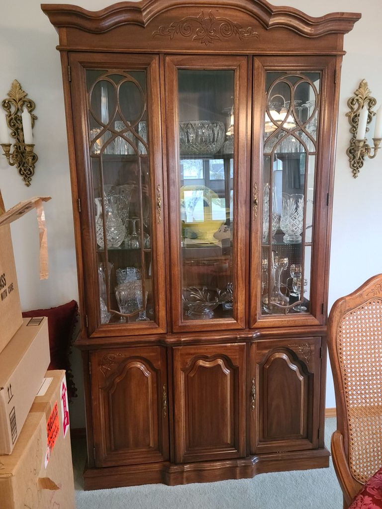 Wood china hutch with glass doors at an estate sale